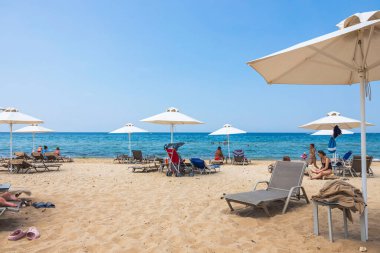 Güneşli yaz gününde kumsaldaki turistlerin güzel manzarası. Yunanistan. Nea Potidaea. 09.03.2021.