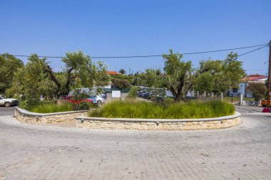 Mavi arka planda park etmiş arabaların olduğu güzel bir yaz manzarası. Yunanistan. 