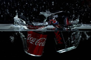 Siyah arka planda suya düşen Coca Cola ve Pepsi Cola 'nın yakın görüntüsü. 0612.2021. İsveç. Uppsala.