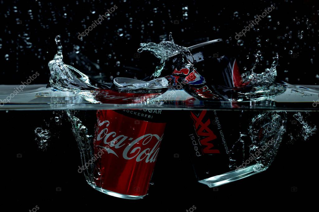 Close up view of coca cola and Pepsi cola falling in water on black background. 0612.2021. Sweden. Uppsala.