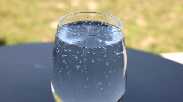 テーブルの上の輝く水のガラスの近くのビュー — ストック動画