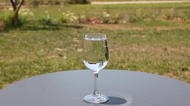 Vista Cerca Del Vaso Agua Con Gas Mesa Patio Con — Vídeo de stock