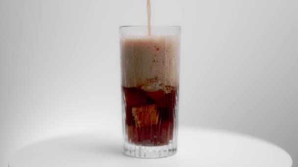 Närbild Hälla Läsk Dryck Ett Glas Med Isbitar Isolerad Bakgrunden — Stockvideo