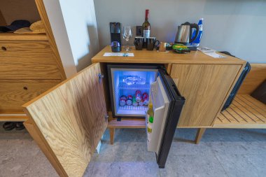 Otel odasındaki açık mini barı, kapsül kahve makinesini ve kahve malzemelerini kapatın. Yunanistan. Nea Potidaea. 09.20.2021