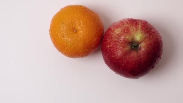 缓慢旋转的红苹果和成熟的橙子果水滴的美丽景色 — 图库视频影像