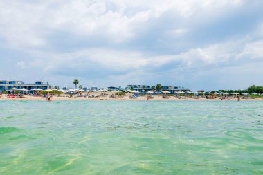 Beautiful view of the resort beach against background of sky with thunderclouds. Greece.