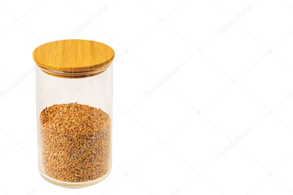 Close up view of glass jar with buckwheat on white background. Concept of cuisine and healthy eating.