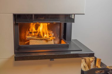 Modern oturma odasındaki şöminede yanan odunların güzel manzarası. İsveç.