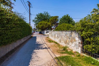 Mavi arka planda park etmiş arabaların olduğu yaz manzarası. Yunanistan. Nea Potidaea. 