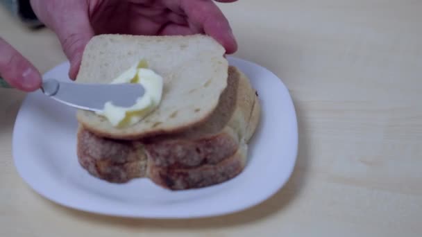 Nahaufnahme Eines Mannes Der Mit Messer Butter Auf Brot Streut — Stockvideo