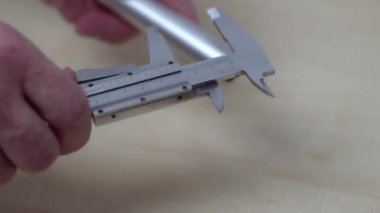 Elektronik kalibreli alüminyum boru ölçen bir adamın yakın görüntüsü. İsveç.