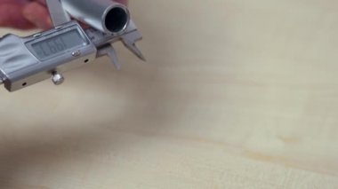 Elektronik kalibreli alüminyum boru ölçen bir adamın yakın çekim görüntüsü. İsveç.