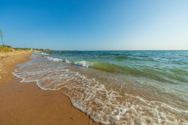 Kum kıyısındaki köpüklü dalgaların muhteşem manzarası. Güzel renkli doğa manzarası arka planlar. Yunanistan. 