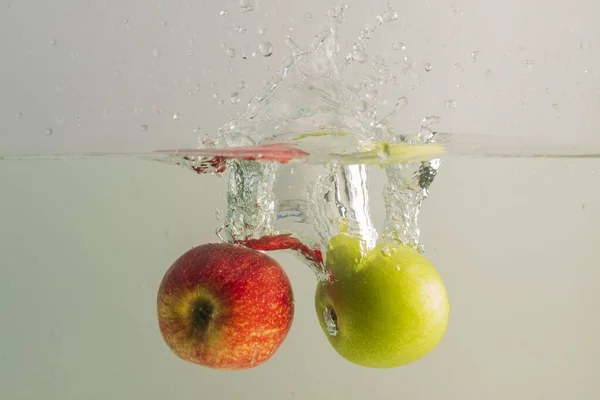 Закройте Вид Падающих Красных Зеленых Аппликаций Воду Концепция Здорового Питания — стоковое фото