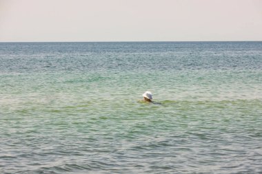 Akdeniz 'in sakin turkuaz sularında yüzen kadının güzel manzarası. Yunanistan.