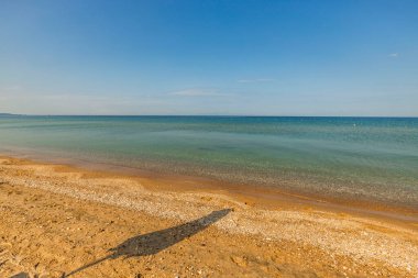 Kumda güneş şemsiyesi yansıması olan Akdeniz sahilinin güzel manzarası. Yunanistan.