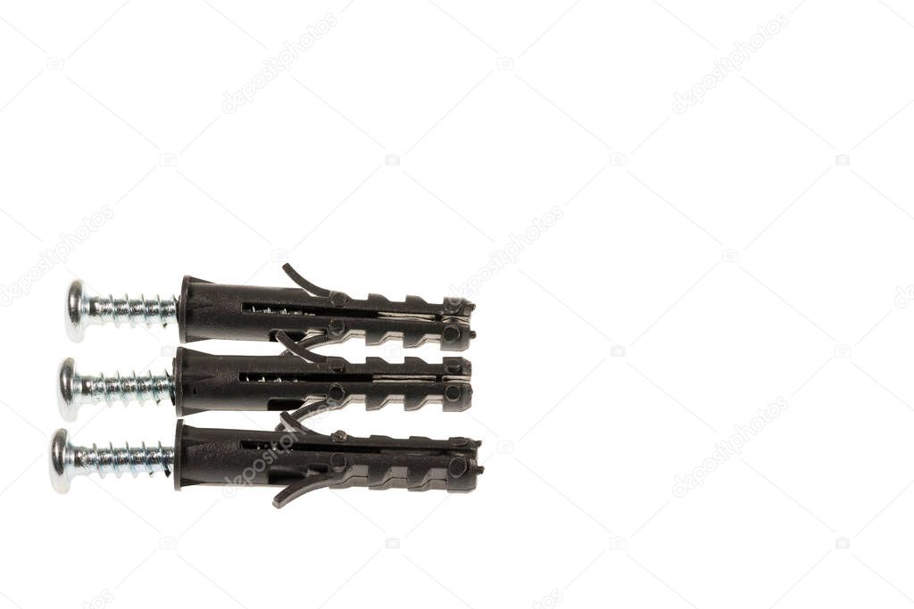Close up view of screws screwed into black plastic screw caps isolated on white background.