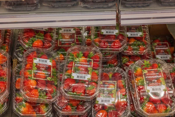 Çilekli plastik kaplara yakından bak. İsveç. Uppsala. 04.21.2022.