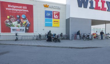 Willy 'nin süpermarketinin önünden geçen insanların güzel görünüşü. İsveç. Uppsala. 04.21.2022.
