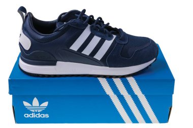 Close up view of blue adidas sneakers with packing box isolated on white background. Sweden. Uppsala. 05.11.2022.