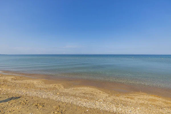 Güzel doğa manzarası. Akdeniz yüzeyi ve ufukta mavi gökyüzü ile birleşen kıyı şeridi. Yunanistan. 