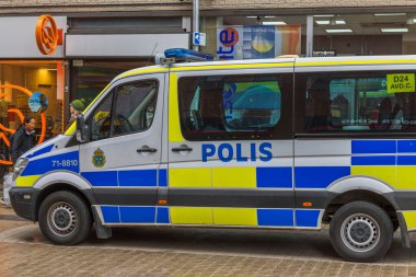 Şehir merkezinde dükkanları ve polis arabası olan turistik yaya bölgesini kapatın. İsveç. Uppsala. 05.14.2022.