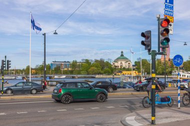 Hareket halindeki arabalarla güzel bir yol manzarası ve Baltık Denizi Körfezi 'ndeki kentsel manzaranın arka planında kırmızı ışık sinyali. İsveç. Stockholm. 05.18.2022.