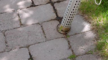 Sokak kiremitleri arasında elektrikli ocakla çimen yakma sürecini kapatın. İsveç. 