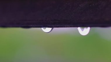 Yağmur sırasında pencerenin penceresinden düşen yağmur damlalarının makro görüntüsü. İsveç.
