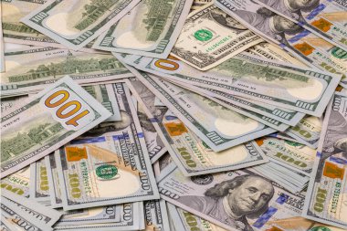 Arka plandaki dağınık 100 dolarlık banknotların yakın görüntüsü. Ekonomi nakit konsepti. İsveç.