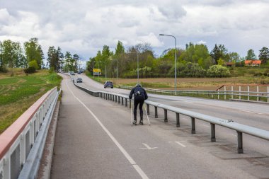 Yazın bisiklet yolunda kayak antrenmanı yapan bir adam. İsveç.