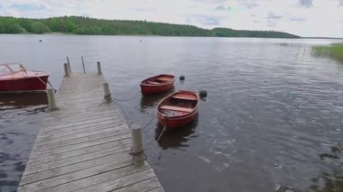 Göl manzarası çok güzel. Arka planda üç tekne var. Güzel doğa manzarası. İsveç. 