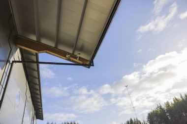 Beyaz bulutlu mavi gökyüzüne karşı çatı evindeki güvenlik kamerası görüntüsü çok güzel. İsveç.