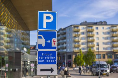 Alışveriş merkezinin yakınındaki otoparkta elektrikli araçları şarj etmek için park yeri işaretini kapat. İsveç.