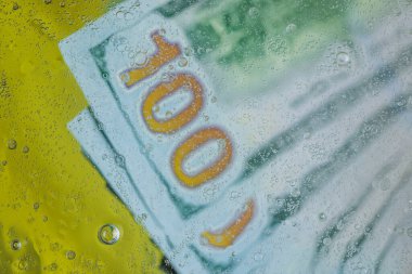 Suyun altındaki yüz dolarlık banknotların bulanık görüntüsünü kapat. Güzel arka planlar.