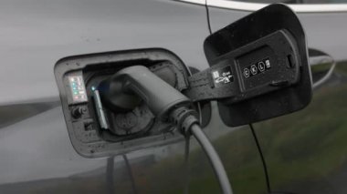 Otoparkta şarj olan elektrikli araba aküsünün yakın görüntüsü. İsveç.