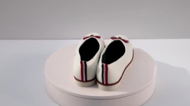 Arka planda izole edilmiş beyaz kadın ayakkabılarının dönüşümlü görüntüsünü kapat. İsveç. Uppsala. 06.25.2022.