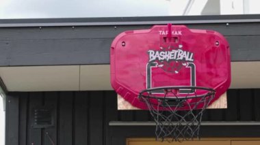 Basketbol antrenmanının manzarası topun potaya fırlatıldığı özel evin bahçesindeki ağ ile. İsveç. Uppsala. 06.25.2022.