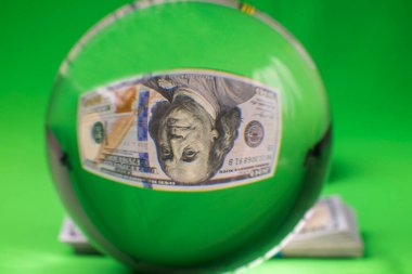 100 dolarlık banknotun ters çevrilmiş görüntüsü olan kristal küre görüntüsü. İsveç.
