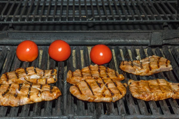 屋外でグリルで肉ステーキやトマトを調理するビュー — ストック写真