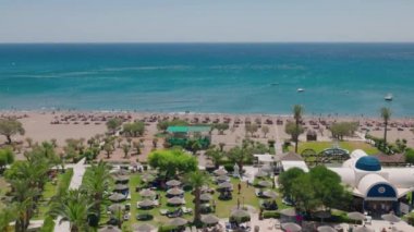 Beautiful breathtaking view from balcony of Pegasos hotel overlooking hotel grounds and beach in Mediterranean sea.  Rhodes. Greece. 07.15.2022.