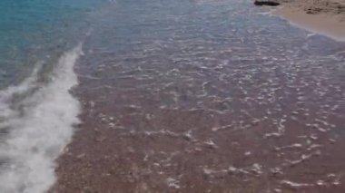 Beautiful view of waves rolling on sandy shore of beach in Mediterranean sea.