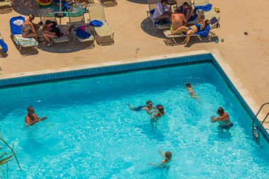 Otelin açık yüzme havuzunda yıkanan turistlerin güzel manzarası. Rodos. Yunanistan. 07.15.2022.