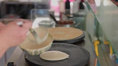 Close up view of woman baking crepes,  thin type of pancakes. Greece. 