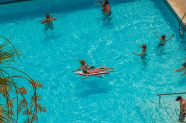Otelin açık yüzme havuzunda yıkanan turistlerin güzel manzarası. Rodos. Yunanistan. 07.15.2022.