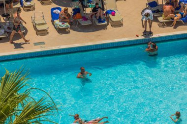 Otelin açık yüzme havuzunda yıkanan turistlerin güzel manzarası. Rodos. Yunanistan. 07.15.2022.