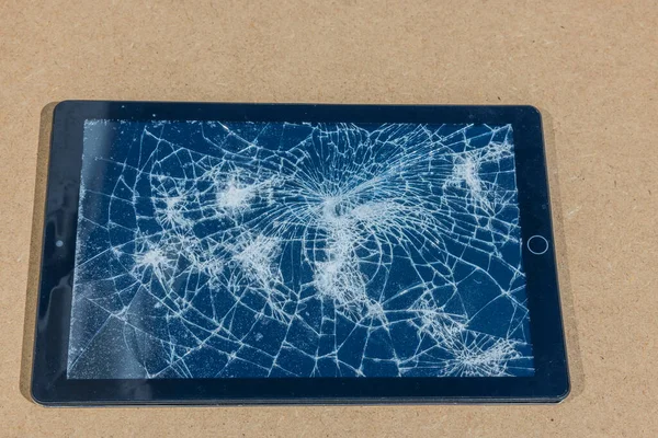 View of electronic tablet with damaged screen isolated on gray background.