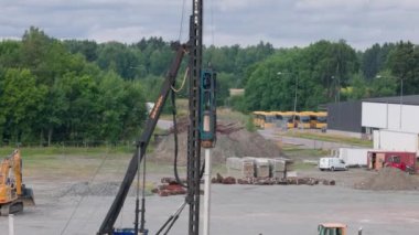View of pile driving machine driving piles into ground construction site. Sweden. Enkoping. 08.05.2022