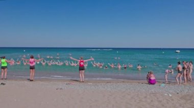 Beautiful view of tourists exercising in water with group of hotel sport instructors. Rhodes. Greece. 08.06.2022. 