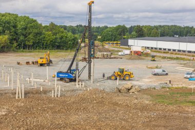 View of building machines in process of driving piles at construction area. Sweden. Enkoping. 08.05.2022.